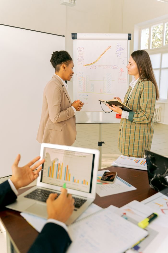 Professionals engage in a dynamic meeting discussing charts and ideas.